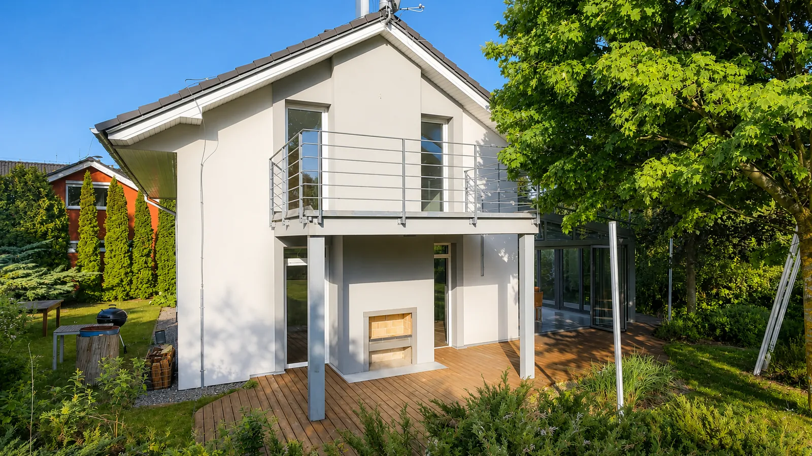 Pohled na dům ze zahrady – balkon, krytá terasa a zimní zahrada.